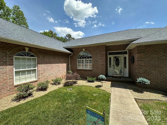 408 Emerald Bay Dr, Salisbury, NC 28146 - property entrance with a shingled roof, a yard, and brick siding