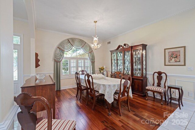 408 Emerald Bay Dr, Salisbury, NC 28146 - dining area with a chandelier, plenty of natural light, ornamental molding, a wainscoted wall, and dark wood finished floors