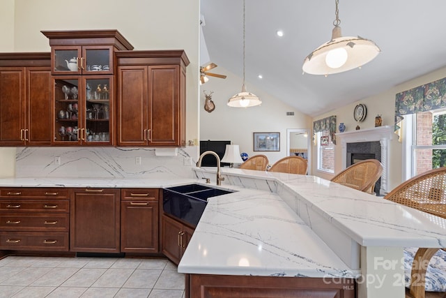 408 Emerald Bay Dr, Salisbury, NC 28146 - kitchen with a sink, a peninsula, a fireplace, glass insert cabinets, and decorative backsplash