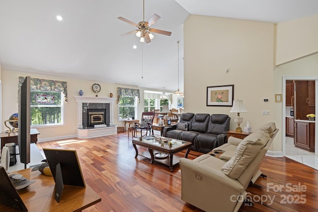 408 Emerald Bay Dr, Salisbury, NC 28146 - living room with a ceiling fan, high vaulted ceiling, a glass covered fireplace, light wood finished floors, and baseboards