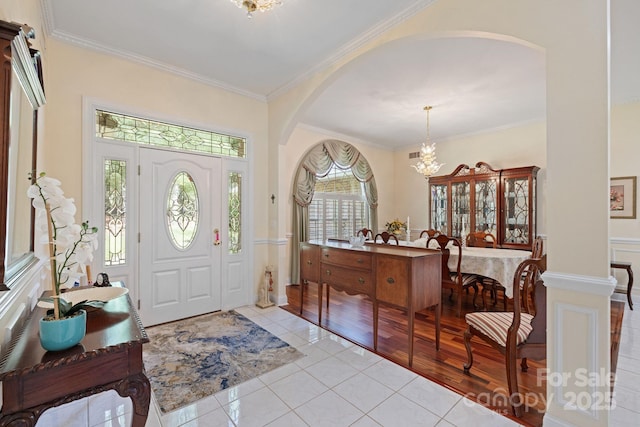408 Emerald Bay Dr, Salisbury, NC 28146 - foyer entrance featuring arched walkways, a chandelier, crown molding, and light tile patterned flooring