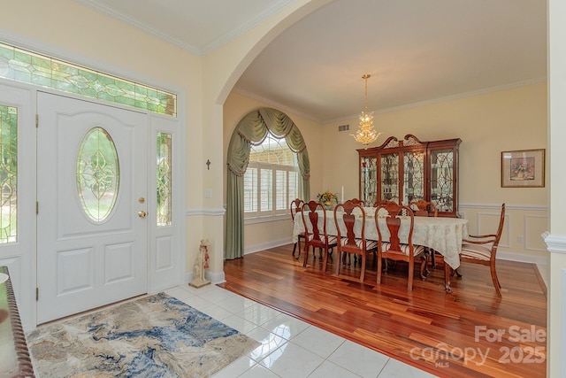 408 Emerald Bay Dr, Salisbury, NC 28146 - entryway with light tile patterned floors, a chandelier, arched walkways, and crown molding