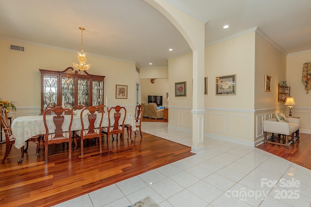 408 Emerald Bay Dr, Salisbury, NC 28146 - dining room featuring light tile patterned floors, arched walkways, crown molding, wainscoting, and decorative columns