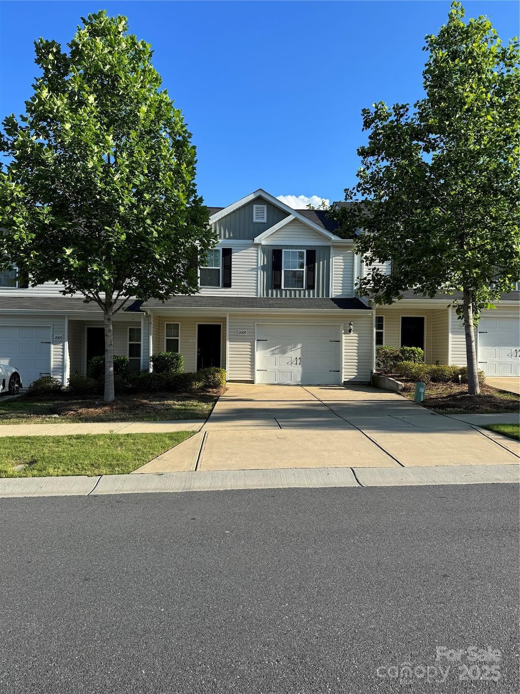 traditional home with driveway, an attached garage, and board and batten siding