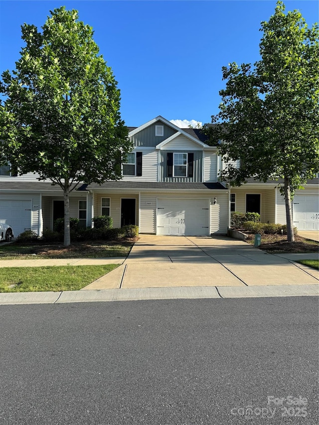 traditional home with driveway, an attached garage, and board and batten siding