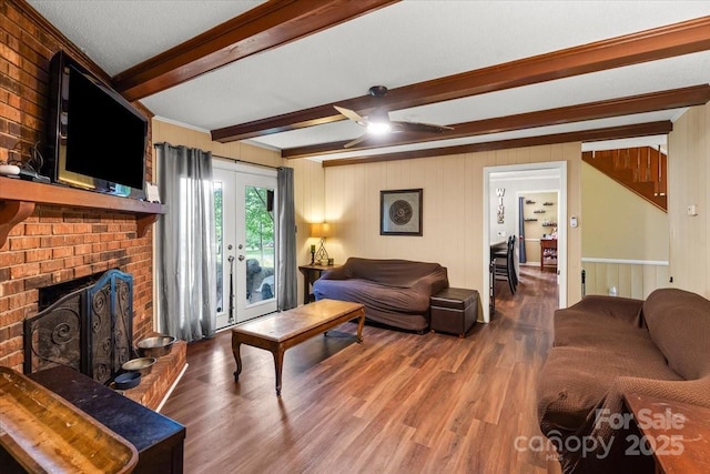 2701 Castes Dr, Pfafftown, NC 27040 - living area featuring wood finished floors, beamed ceiling, a ceiling fan, a fireplace, and french doors