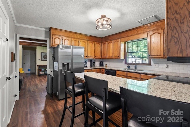 2701 Castes Dr, Pfafftown, NC 27040 - kitchen with a sink, stainless steel refrigerator with ice dispenser, brown cabinetry, black dishwasher, and a peninsula