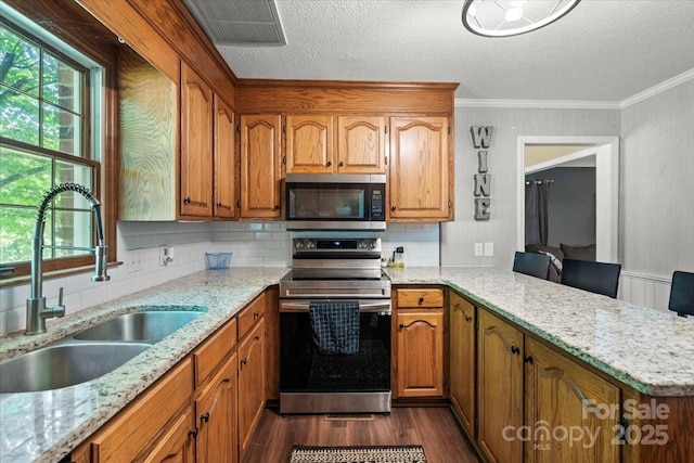 2701 Castes Dr, Pfafftown, NC 27040 - kitchen featuring appliances with stainless steel finishes, a sink, dark wood-type flooring, a textured ceiling, and brown cabinetry