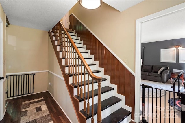 2701 Castes Dr, Pfafftown, NC 27040 - stairway with wood finished floors and a wainscoted wall