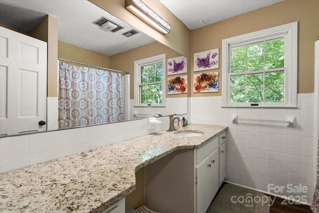 2701 Castes Dr, Pfafftown, NC 27040 - bathroom featuring tile walls, vanity, a wainscoted wall, and curtained shower