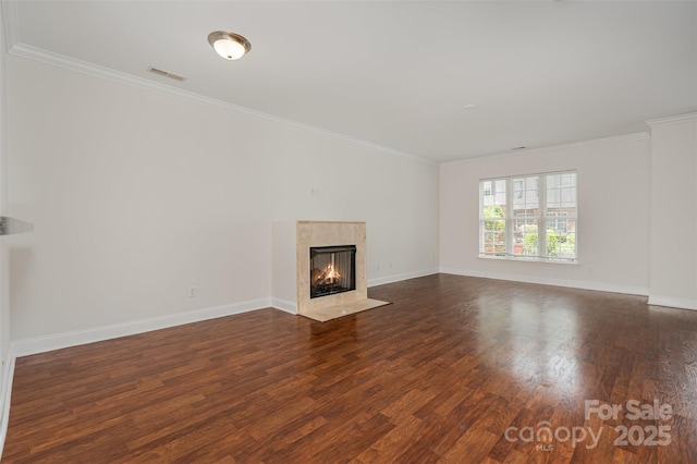 unfurnished living room featuring crown molding, dark wood-style floors, a high end fireplace, and baseboards