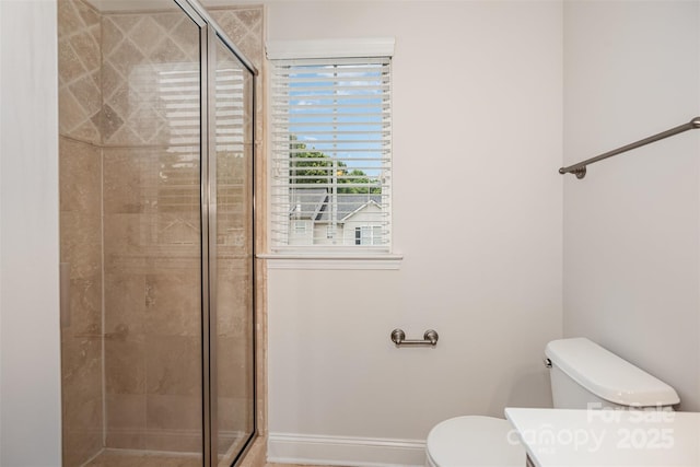 bathroom with a shower stall, toilet, baseboards, and vanity