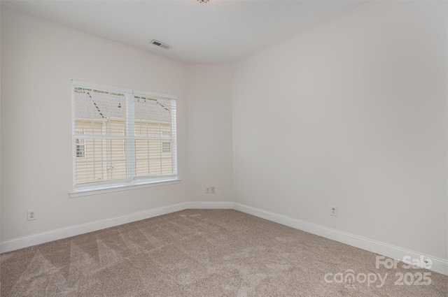 carpeted empty room featuring baseboards