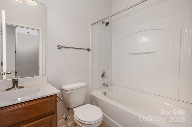 bathroom featuring toilet, vanity, shower / bathtub combination, and baseboards