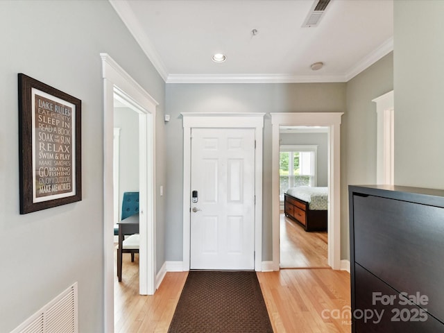 entryway featuring light wood-style floors, ornamental molding, recessed lighting, and baseboards