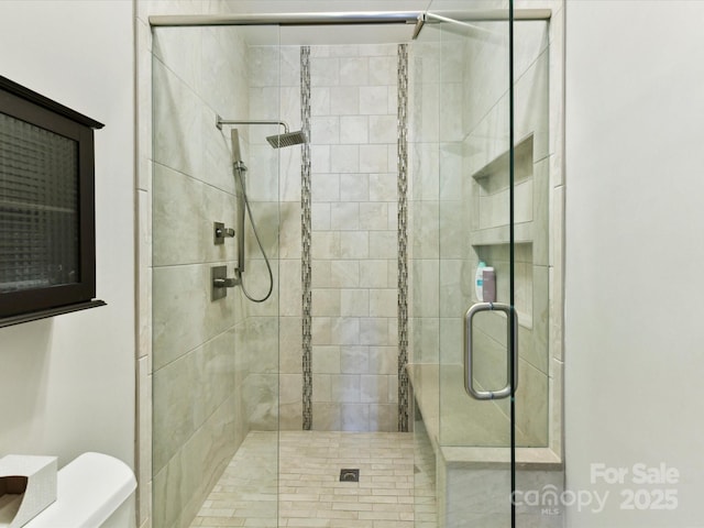 full bathroom featuring a shower stall and toilet