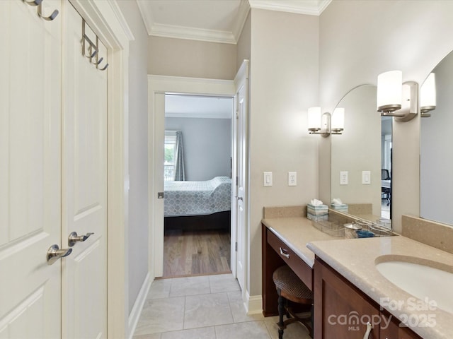 bathroom featuring vanity, crown molding, baseboards, and ensuite bath
