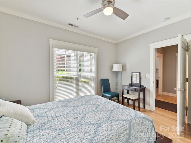 bedroom featuring crown molding, wood finished floors, a ceiling fan, and baseboards