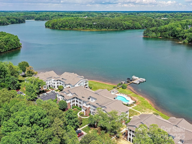 drone / aerial view of a large body of water and a heavily wooded area