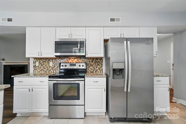8014 Sherington Way, Charlotte, NC 28227 - kitchen with stainless steel appliances, white cabinets, tasteful backsplash, and light stone countertops