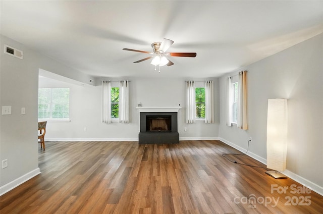 8014 Sherington Way, Charlotte, NC 28227 - unfurnished living room featuring a ceiling fan, wood finished floors, a fireplace with raised hearth, and baseboards