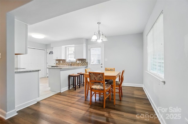 8014 Sherington Way, Charlotte, NC 28227 - dining room with a chandelier, wood finished floors, and baseboards