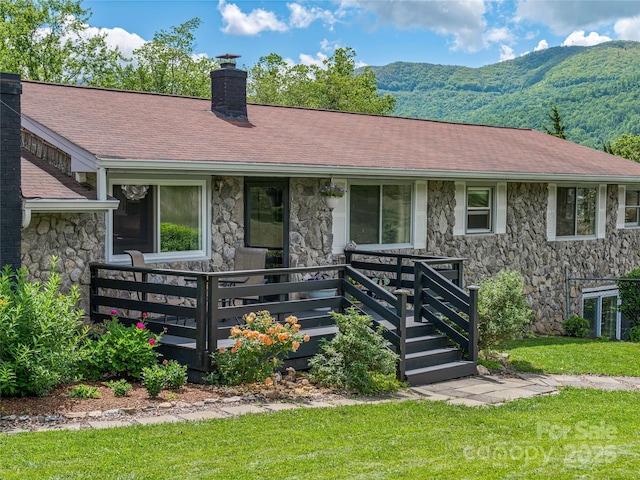 143 Mountain Crest Rd, Swannanoa, NC 28778 - view of front of house with stone siding, a chimney, a deck with mountain view, and a front yard