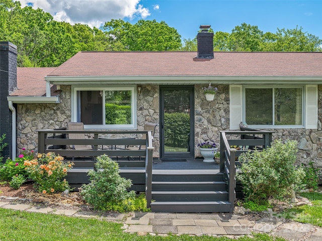 143 Mountain Crest Rd, Swannanoa, NC 28778 - view of exterior entry with stone siding, a chimney, a deck, and a shingled roof