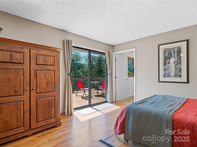 143 Mountain Crest Rd, Swannanoa, NC 28778 - bedroom with access to outside, light wood-style flooring, and a textured ceiling
