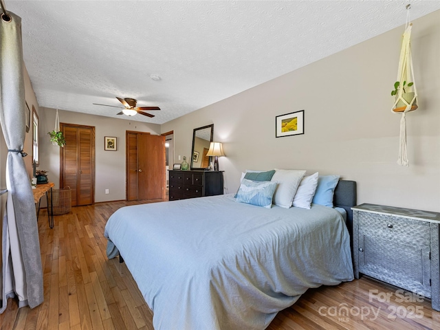 143 Mountain Crest Rd, Swannanoa, NC 28778 - bedroom with hardwood / wood-style floors, two closets, a textured ceiling, and ceiling fan