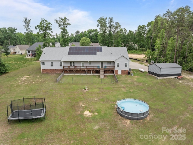 1230 Long Creek Ln, Salisbury, NC 28146 - back of property with a trampoline, a wooden deck, an outdoor pool, crawl space, and solar panels