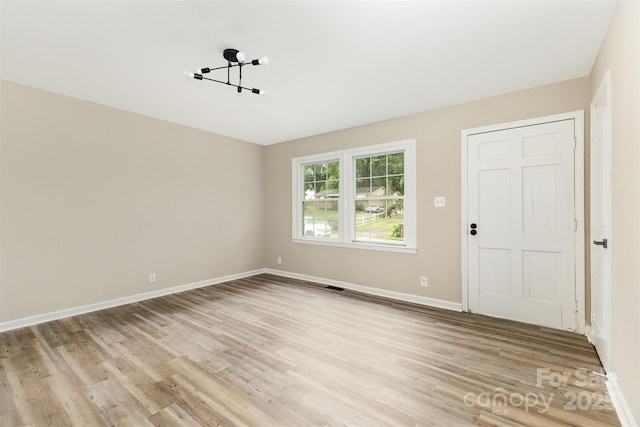 16 Green St, York, SC 29745 - unfurnished room featuring light wood-style floors, a chandelier, and baseboards