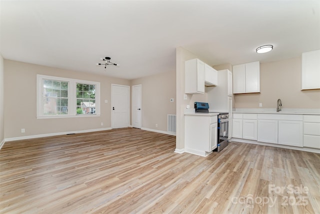 16 Green St, York, SC 29745 - kitchen with stainless steel electric range oven, light wood-style floors, and light countertops
