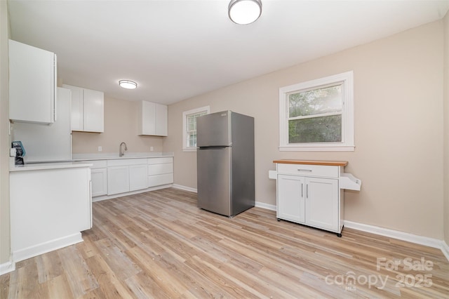16 Green St, York, SC 29745 - kitchen with freestanding refrigerator, light wood-style floors, white cabinetry, baseboards, and light countertops
