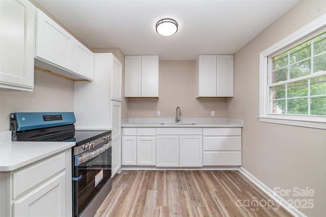 16 Green St, York, SC 29745 - kitchen featuring electric range, a sink, light wood-style floors, light countertops, and white cabinets