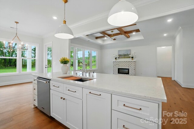 9311 Simpson Rd, Waxhaw, NC 28173 - kitchen with stainless steel dishwasher, a sink, coffered ceiling, a brick fireplace, and white cabinetry