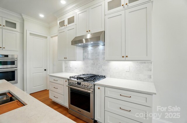 9311 Simpson Rd, Waxhaw, NC 28173 - kitchen with stainless steel appliances, under cabinet range hood, wood finished floors, decorative backsplash, and recessed lighting