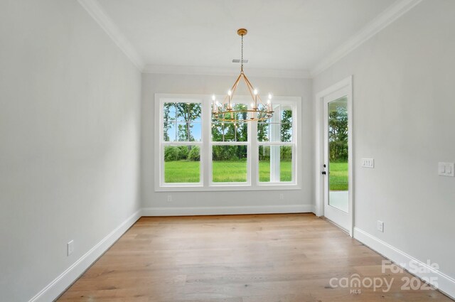 9311 Simpson Rd, Waxhaw, NC 28173 - unfurnished dining area with plenty of natural light, a chandelier, ornamental molding, and wood finished floors