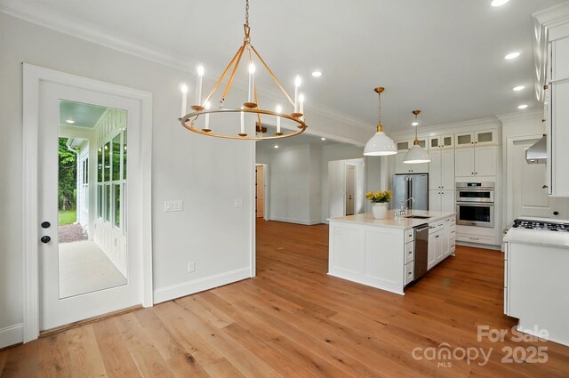 9311 Simpson Rd, Waxhaw, NC 28173 - kitchen with appliances with stainless steel finishes, light countertops, white cabinetry, light wood-type flooring, and crown molding