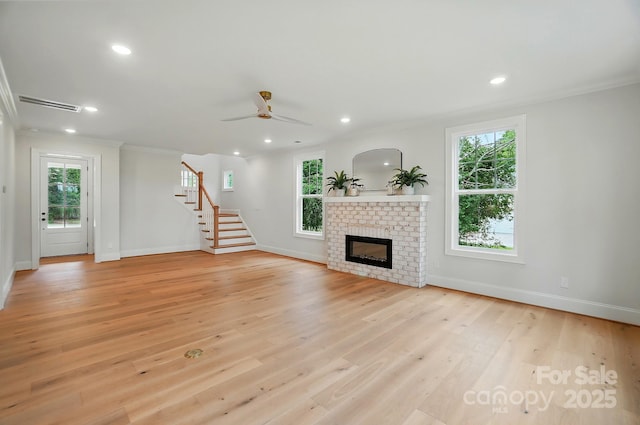 9315 Simpson Rd, Waxhaw, NC 28173 - unfurnished living room with crown molding, baseboards, a fireplace, stairway, and light wood-style flooring