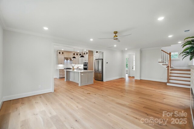 9315 Simpson Rd, Waxhaw, NC 28173 - unfurnished living room with ceiling fan, crown molding, baseboards, stairway, and light wood finished floors