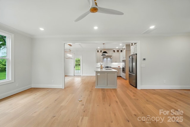 9315 Simpson Rd, Waxhaw, NC 28173 - kitchen featuring high end fridge, crown molding, plenty of natural light, a center island with sink, and white cabinets