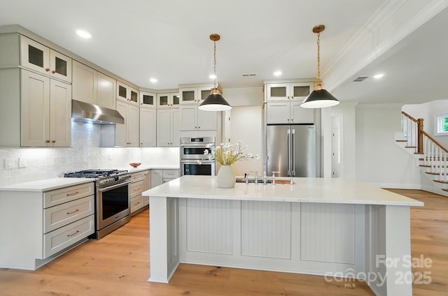 9315 Simpson Rd, Waxhaw, NC 28173 - kitchen featuring appliances with stainless steel finishes, under cabinet range hood, a kitchen island, ornamental molding, and a sink