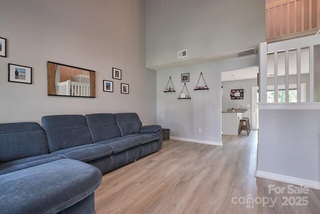 327 Wilkes Place Dr, Fort Mill, SC 29715 - living area with a high ceiling, light wood-style floors, and baseboards