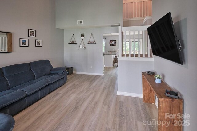 327 Wilkes Place Dr, Fort Mill, SC 29715 - living room featuring wood finished floors, baseboards, and a towering ceiling
