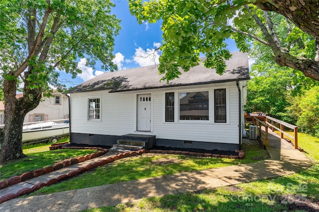 view of front of property featuring a front lawn, crawl space, and central AC unit
