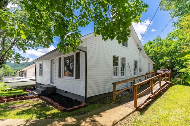 view of side of home featuring a yard and crawl space