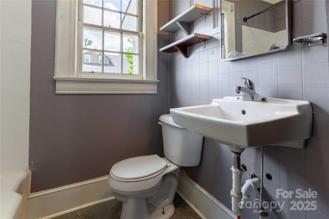 bathroom featuring tile walls and toilet
