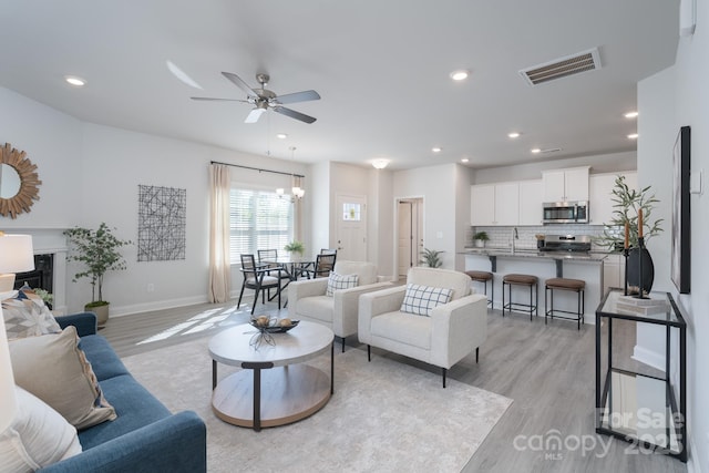 4045 Port Richmond Ave Unit 10, Gastonia, NC 28056 - living area featuring light wood-type flooring, a ceiling fan, recessed lighting, baseboards, and a chandelier