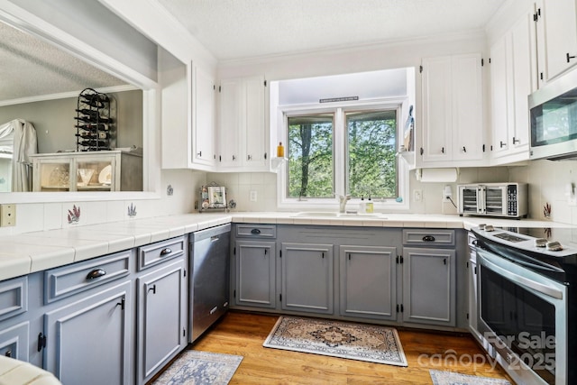334 Lakeview Cir, Lugoff, SC 29078 - kitchen with appliances with stainless steel finishes, a sink, ornamental molding, gray cabinetry, and backsplash